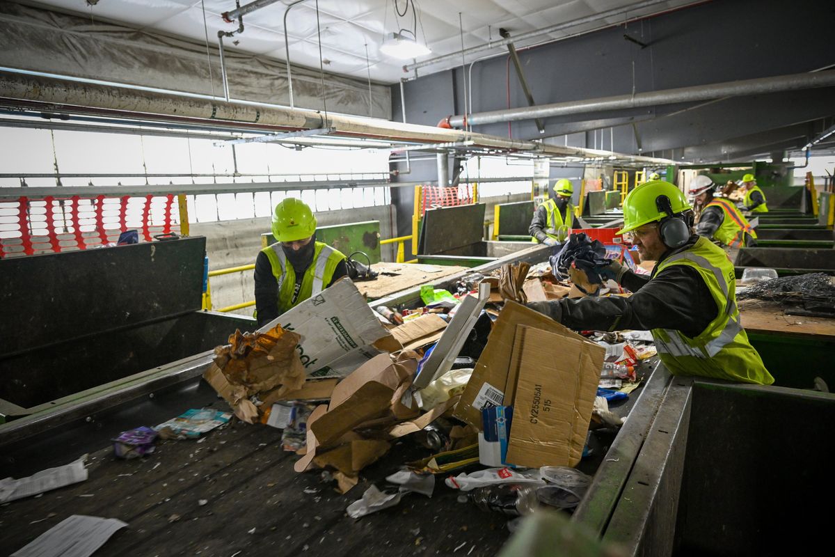 A half-dozen workers quickly grab sheet plastic, cloth, plastic bags, rope or oversized pieces at the first sorting area that could cause the sorting belts and machines to break down last month at the Spokane Materials and Recycling Technology center.  (Jesse Tinsley/THE SPOKESMAN-REVIEW)