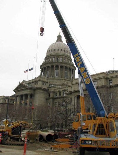 
Workers on Tuesday operate a drilling rig that's boring test and dewatering wells on the lawn outside the Capitol. 
 (Associated Press / The Spokesman-Review)