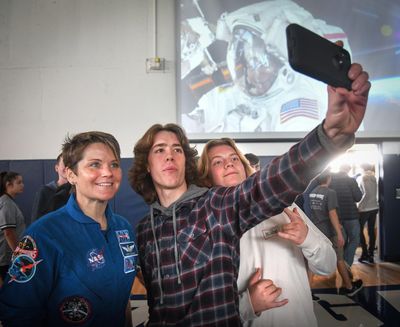 NASA astronaut and Gonzaga Prep grad Anne McClain has a picture taken with G-Prep juniors Timmy Craven and Liam Arnold after an assemble at the school, Thursday, Oct. 10, 2019, in Spokane, Wash. (Dan Pelle / The Spokesman-Review)