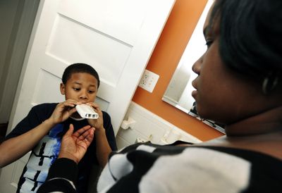 Syeadda Spears watches as her son Da’Shawn, 9, who has asthma, blows into a peak flow meter, which measures his ability to push air out of his lungs.  The Baltimore Sun (Algerina Perna The Baltimore Sun / The Spokesman-Review)