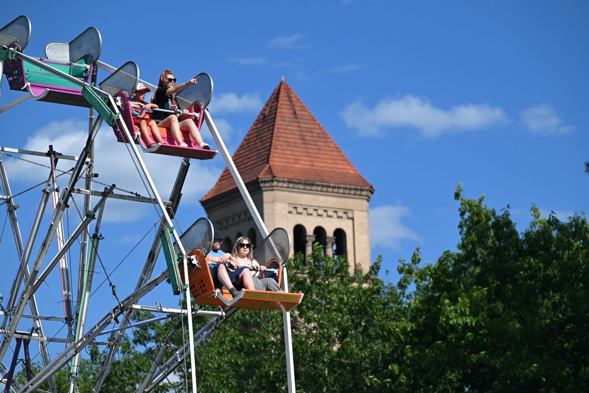 Aldina Bajramovic, in the upper seat, points out the sights to Jaxson Rukkila, 7, as they are some of first to ride the Ferris wheel Wednesday at the ICCU Summer Carnival set up in Riverfront Park.  (Jesse Tinsley/THE SPOKESMAN-REVIEW)