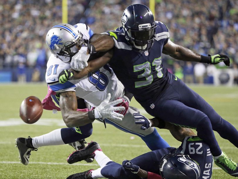 Seahawks strong safety Kam Chancellor (31) knocks the ball loose from Detroit Lions wide receiver Calvin Johnson in the critical play of Seattle’s victory on Monday night (Elaine Thompson / AP)