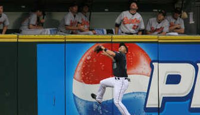 
Seattle left fielder Raul Ibanez tries to get to the second-inning home-run ball of Baltimore's Ramon Hernandez.Associated Press
 (Associated Press / The Spokesman-Review)