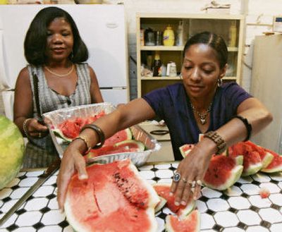 
Janet Riley, left, of Calumet City, Ill., works with her cousin Gail Williams, 46, from Metairie, La., as they prepare food for a community function at Riley's church in Chicago. 
 (Associated Press / The Spokesman-Review)