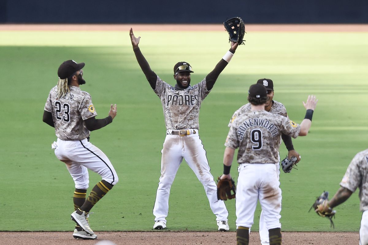 San Diego Padres’ Fernando Tatis Jr. (23), Jurickson Profar (10), and Jake Cronenworth (9) celebrate after the Padres beat the Seattle Mariners in a baseball game Sunday, Sept. 20, 2020, in San Diego. The Padres clinched a spot in the playoffs.  (Denis Poroy)