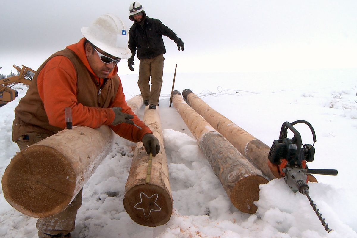 Pulu Longopoa, in front, and Jeremy Lundberg, contractors for Avista Utilities, work at replacing four power poles that snapped from the weight of ice buildup just south of Davenport on Thursday, Jan. 22, 2009. The freezing fog buildup, which has felled trees and power lines through the week, is the worst many residents of Lincoln County say they have ever seen. (Colin Mulvany / The Spokesman-Review)