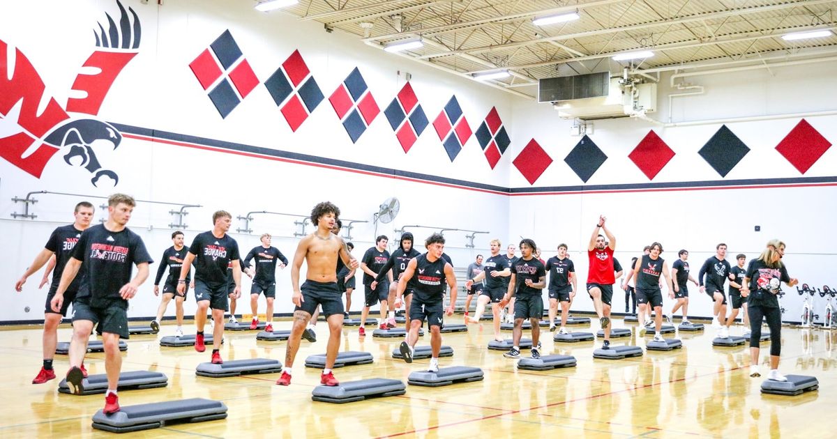 Eastern football team takes part in step aerobics class with university president