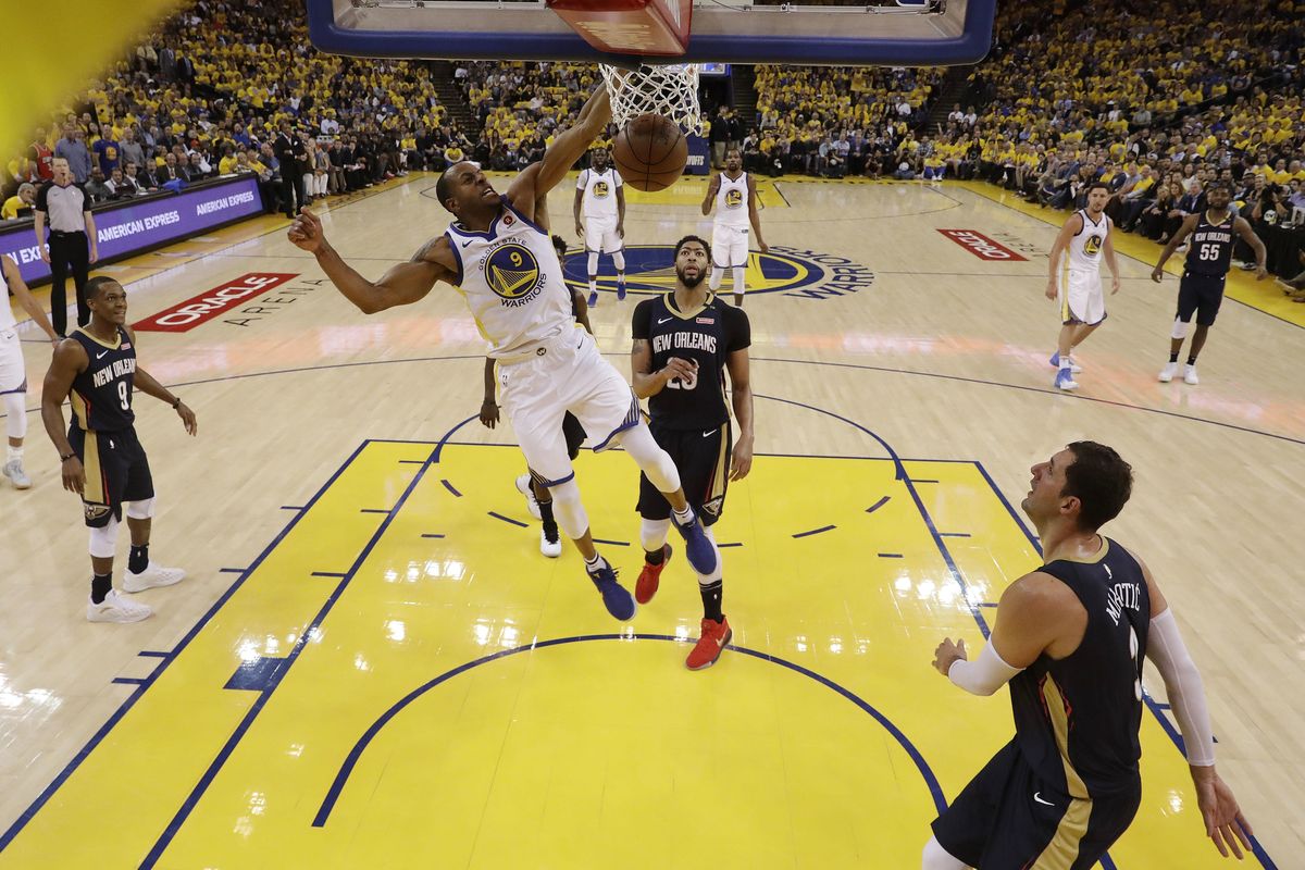 Golden State Warriors’ Andre Iguodala (9) dunks past New Orleans Pelicans’ Anthony Davis, center, during the first half in Game 5 of an NBA basketball second-round playoff series Tuesday, May 8, 2018, in Oakland, Calif. (Marcio Jose Sanchez / Associated Press)