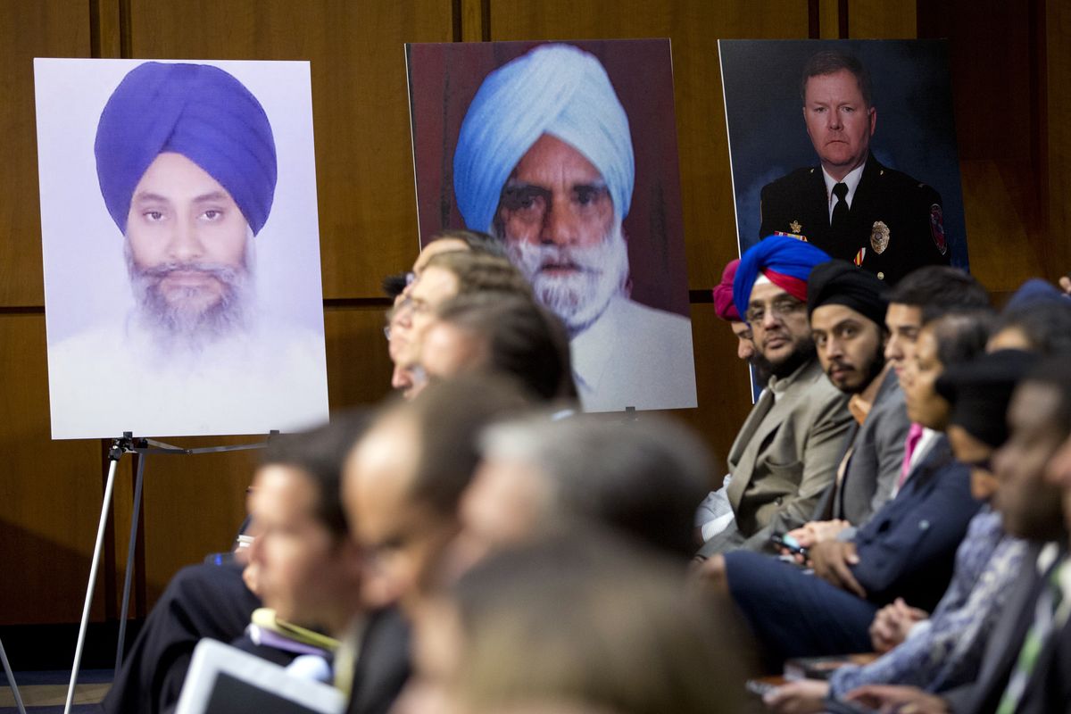 Photographs of the victims of the attack that left six Sikh worshipers dead in Oak Creek, Wis., line the walls during a hearing on Capitol Hill on Wednesday, Sept. 19, 2012 in Washington. (Evan Vucci / Associated Press)