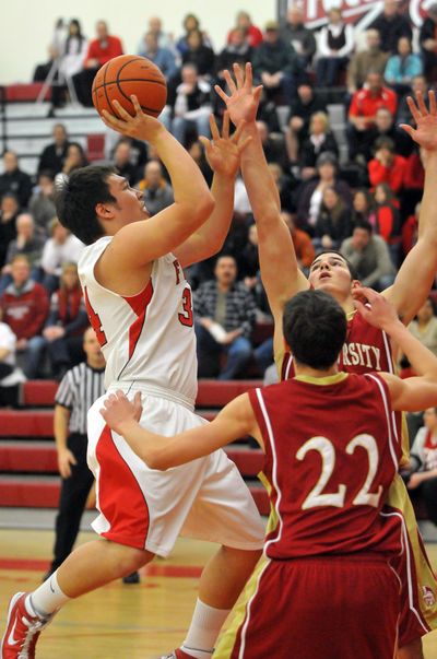 Ferris’ Taylor Kamitomo tries to get off a jumper over University defenders Brett Bailey (22) and Joe Dahl.  (Jesse Tinsley)