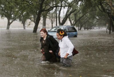 
Alison Mantilla, left and McNally Sislo walk in high water in New Orleans on Thursday. 
 (Associated Press / The Spokesman-Review)