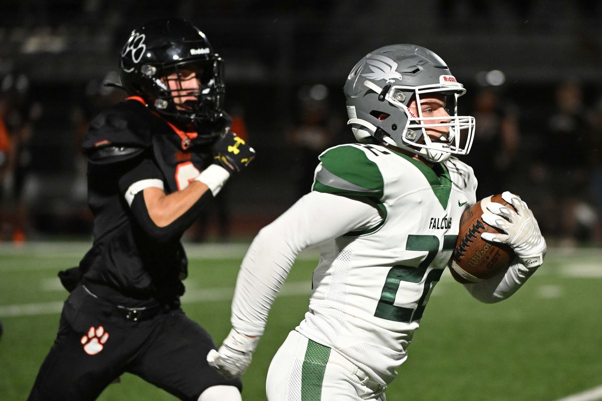 Ridgeline Falcons Kole LeGrant (22) breaks away from Lewis and Clark Tigers Cooper Jeffries (2) for a touchdown in the first half at Ridgeline High School on Thurs. Sept. 21, 2023 in Liberty Lake WA.  (James Snook)