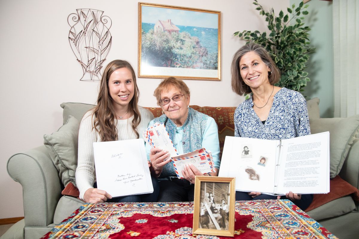 Delores Lorenz, center, holds letters written during the Vietnam war by her late husband, Jim, as her daughter, Rachel Lorenz Devlin (right) and her granddaughter, Allison Grefsrud, hold books that Delores had created for them at her home in Spokane on Oct. 29, 2020. Lorenz is nearing completion of her pandemic project, in which she has written about her life growing up and onward through raising a family, and will gift copies to her sons and Rachel as well as their children.  (Libby Kamrowski/ THE SPOKESMAN-REVIEW)