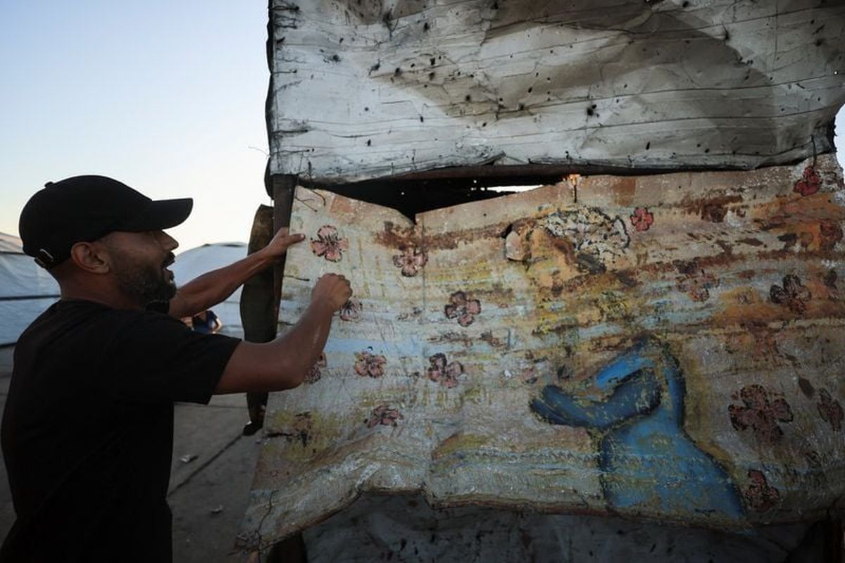 A Palestinian man shows damage at the site of an Israeli strike at a cafe at the seaport of Gaza City on Sunday. (Reuters )