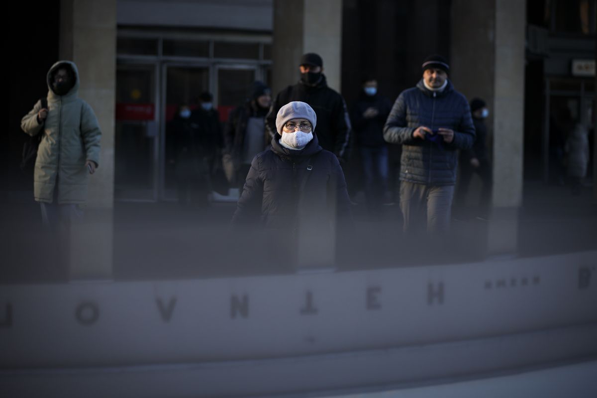 A woman wearing a face mask to help curb the spread of the coronavirus walks into the underpass under the street during sunset in Moscow, Russia, Wednesday, Dec. 2, 2020. Russia has registered a record number of coronavirus deaths for a second straight day. Currently, there is a country-wide mask mandate and mostly mild restrictions that vary from region to region.  (Alexander Zemlianichenko)