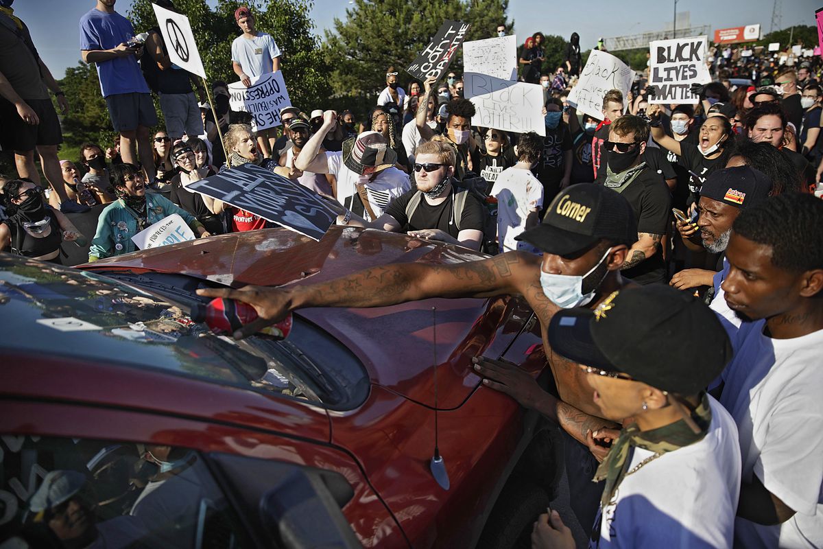 In this Sunday, May 31, 2020 photo, protesters surround a truck shortly before it drove through the group injuring several on Interstate 244 in Tulsa, Okla. The group was protesting the killing of George Floyd by Minneapolis police on May 25 and commemorating the 1921 Tulsa Race Massacre. (Mike Simons)
