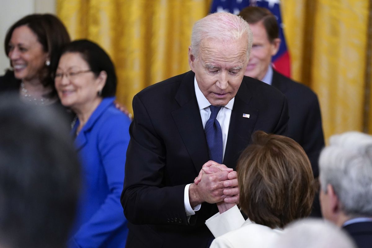 In this May 20, 2021 photo, President Joe Biden holds House Speaker Nancy Pelosi