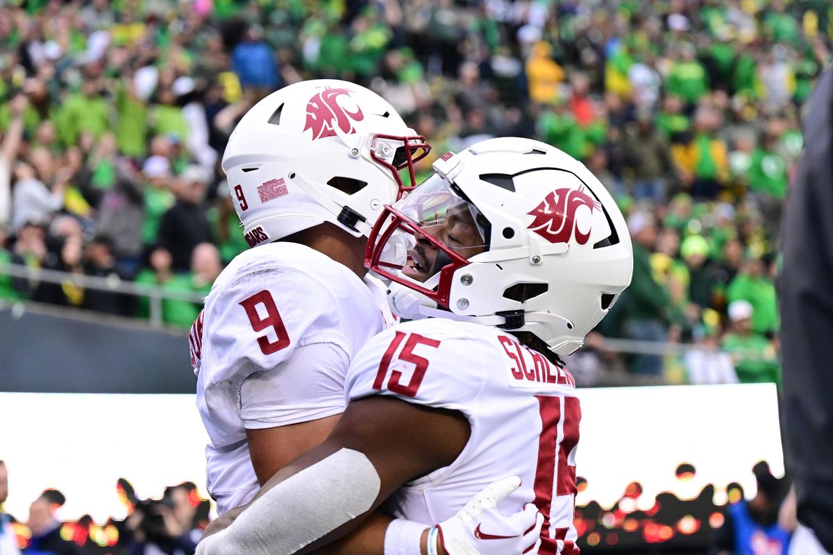 Washington State running back Djouvensky Schlenbaker (15) hugs receiver Isaiah Hamilton after he scored a touchdown during the second half Oct. 21 in Eugene.  (Tyler Tjomsland/The Spokesman-Review)