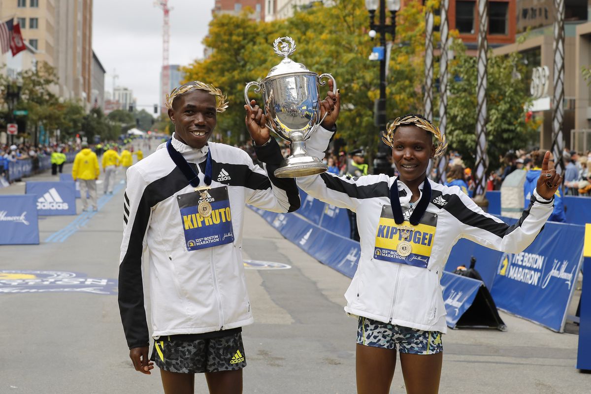 Benson Kipruto, left, and Diana Kipyogei, both of Kenya, celebrate winning the men