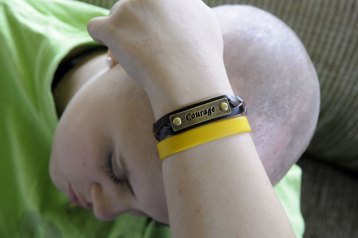 Carissa Outen works on math problems with a tutor at her home May 13, 2010. On her wrist she wears a courage bracelet given to her by an Albertson's customer. (Dan Pelle / The Spokesman-Review)