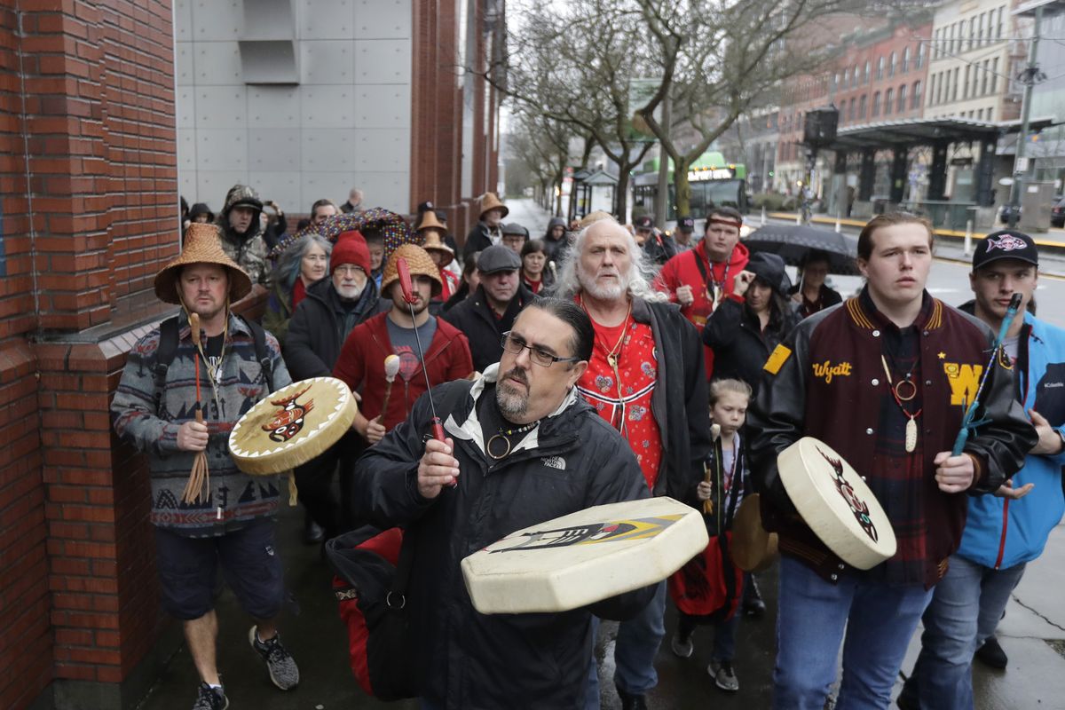 Tony A. (Naschio) Johnson, center, elected chairman of the Chinook Nation, plays a drum as he leads tribal members and supporters as they march to the federal courthouse on Jan. 6 in Tacoma, as they continue their efforts to regain federal recognition amid a global pandemic. (Ted S. Warren)