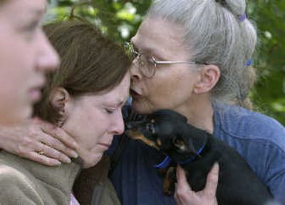 
Linda Perez, right, and her dog, Nikki, comfort Stacy Hollister on Tuesday after a fire at their building. 
 (Dan Pelle / The Spokesman-Review)