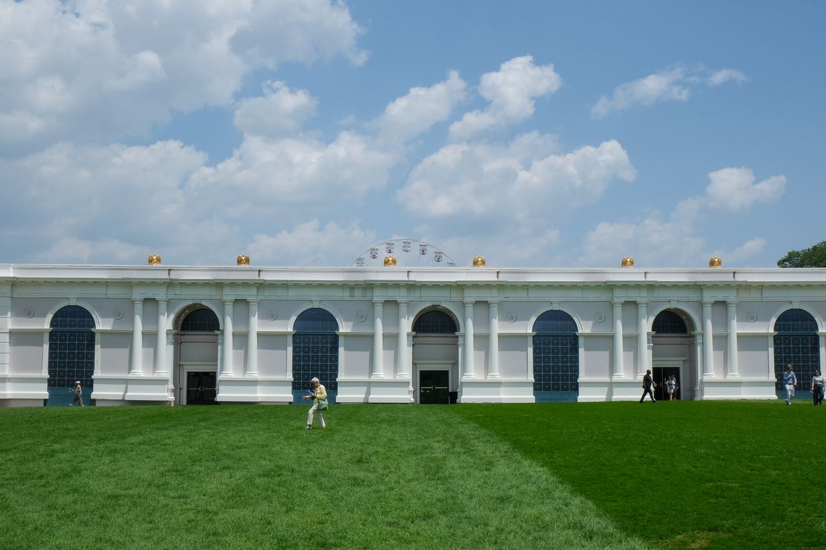 An attendee walks in front of a tent painted to resemble the White House colonnade the Great American State Fair on the National Mall in Washington, D.C., on July 1, 2026. 