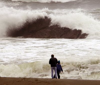 Beachcombers watch as storm-tossed waves crash over rocks near Depoe Bay, Ore. (Associated Press / The Spokesman-Review)