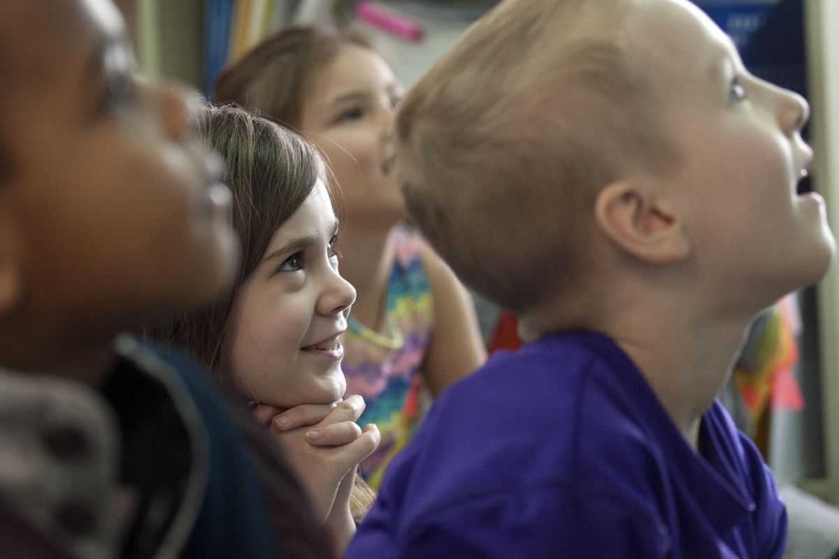 Eden Williams, center, listens to teacher Marion Bageant in her first grade class at  Garfield Elementary on Wednesday, Jan. 16, 2019.  Bageant is using visual thinking strategies, or VTS, a teaching method for younger students that relies on reflect-and-response techniques. (Kathy Plonka / The Spokesman-Review)