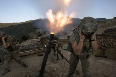 Soldiers from the U.S. Army First Battalion, 26th Infantry fire mortars from the Korengal Outpost at Taliban positions in the Korengal Valley of Afghanistan’s Kunar province on Tuesday. (Associated Press / The Spokesman-Review)