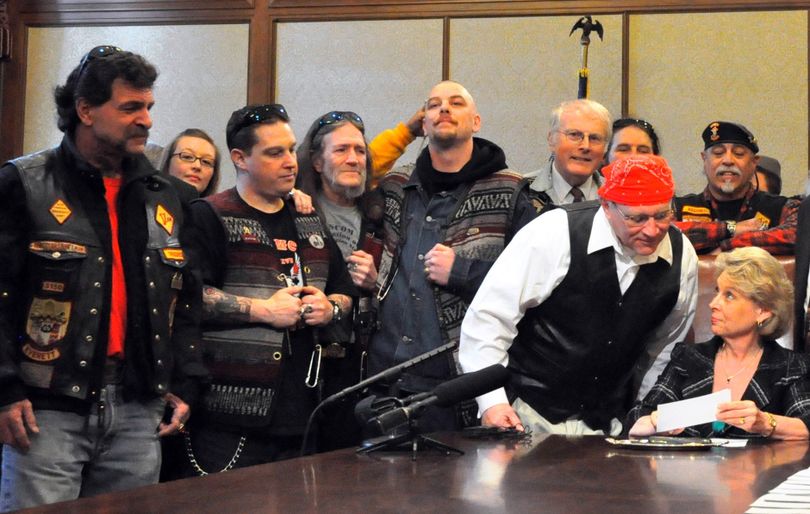 Biker bill: Washington Sen. Jim Hargrove, D-Hoquiam, dressed in his riding leathers, leans in Wednesday to see Gov. Chris Gregoire sign a bill to ban motorcycle profiling in the state. (Jim Camden)