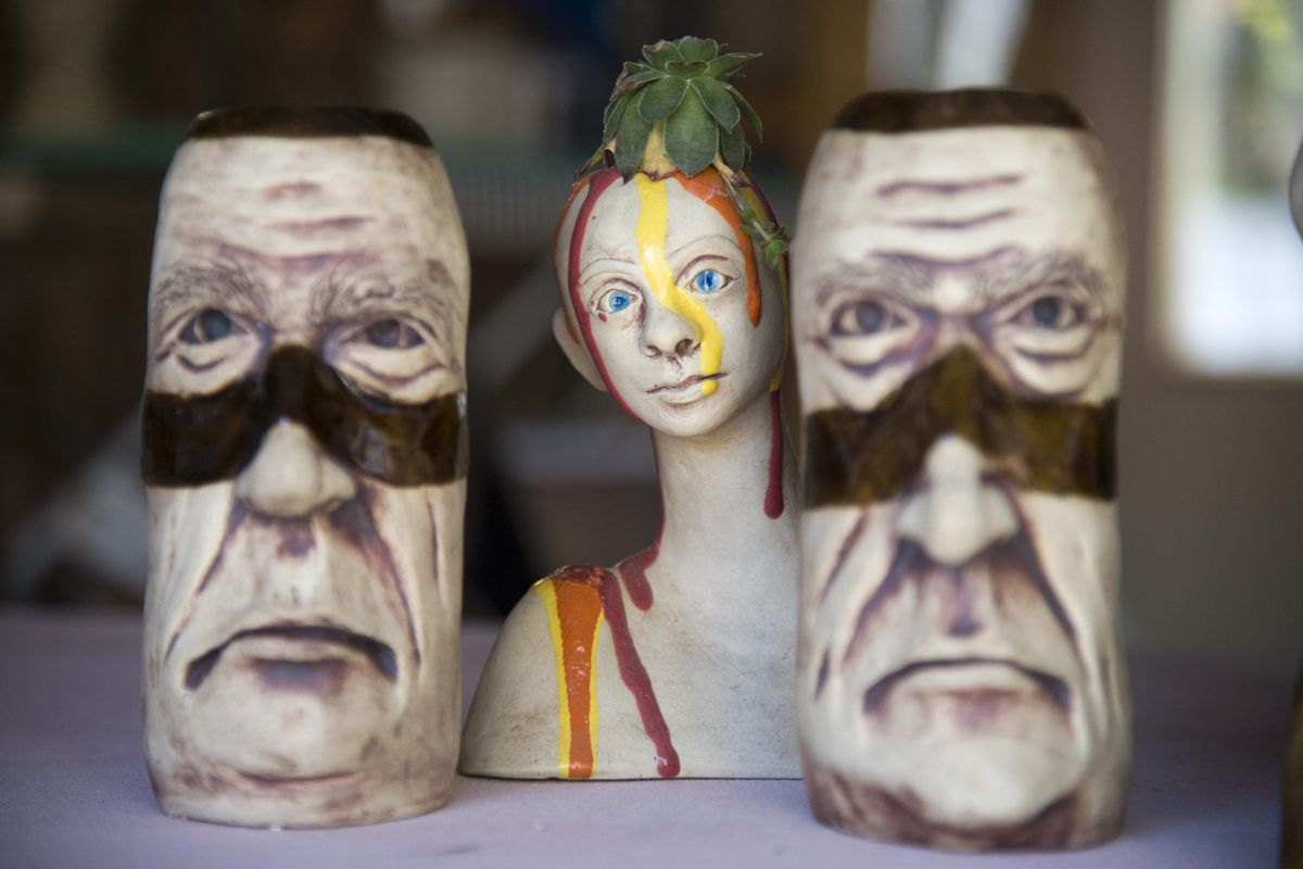 Aryn Lindsey Fields creates faces on a small decorative pieces in her garage studio, shown Wednesday in Spokane. (Jesse Tinsley / The Spokesman-Review)