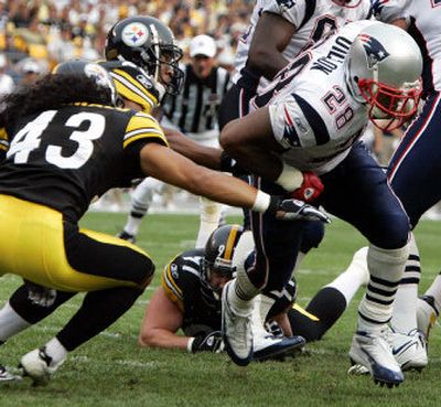 
Pariots running back Corey Dillon reaches gets past Steelers defenders Troy Polamalu (43) and Chris Hope for a 4-yard touchdown run in the first quarter of New England's 23-20 victory at Heinz Field. Dillon scored two touchdowns. 
 (Associated Press / The Spokesman-Review)