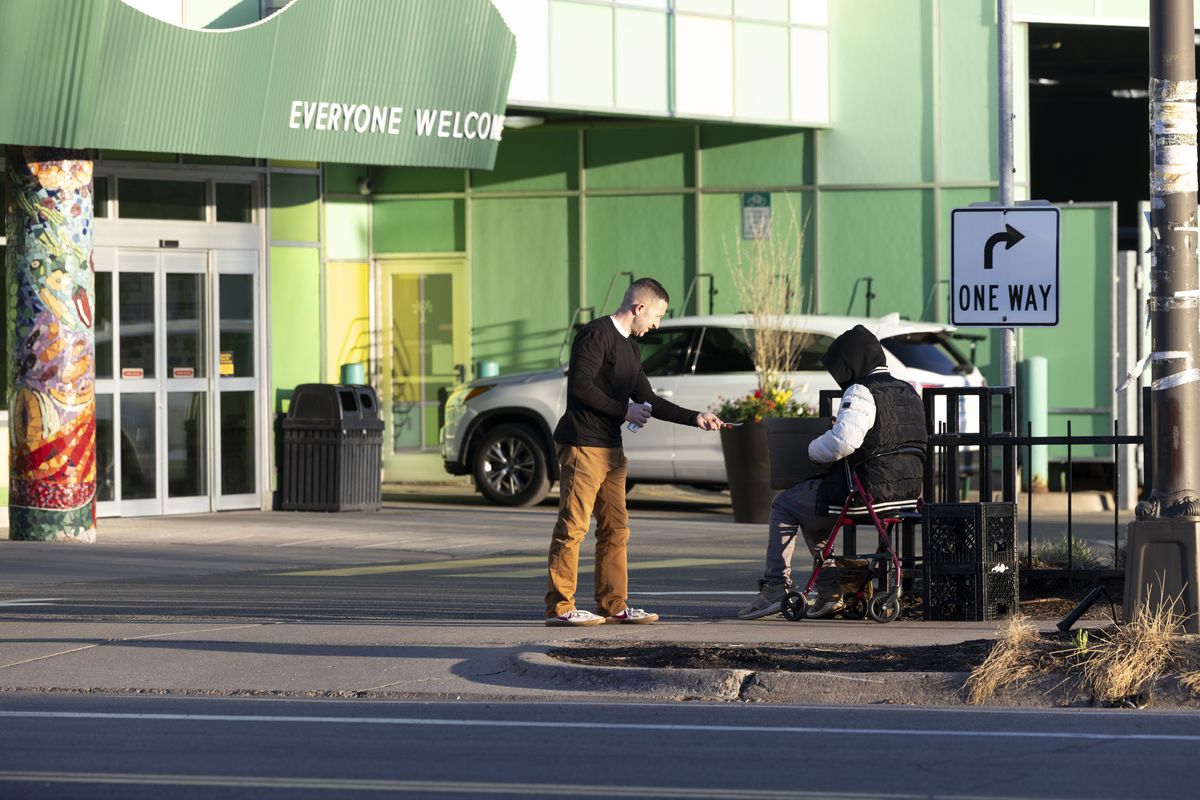 Reid Kennedy delivers a care package in Minneapolis. When choosing recipients, he said he looks for clues that the person might need nourishment.  (Jenn Ackerman/for the Washington Post)