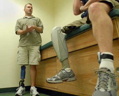 
Michael McNaughton, left, who lost a leg after stepping on a mine in Afghanistan, talks with Bill Dunham, who lost his leg in a friendly fire accident in Panama in 1989, at Schindler's Orthotic and Prosthetic Services on Wednesday in Spokane. 
 (Jesse Tinsley / The Spokesman-Review)