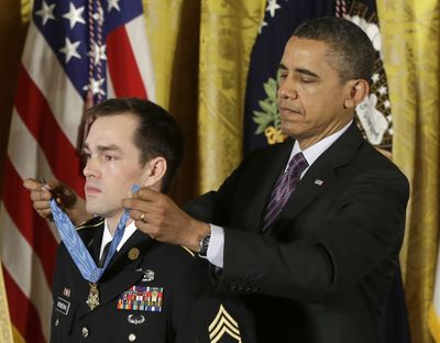 President Barack Obama places the Medal of Honor on retired Staff Sgt. Clinton Romesha on Monday. (Associated Press)