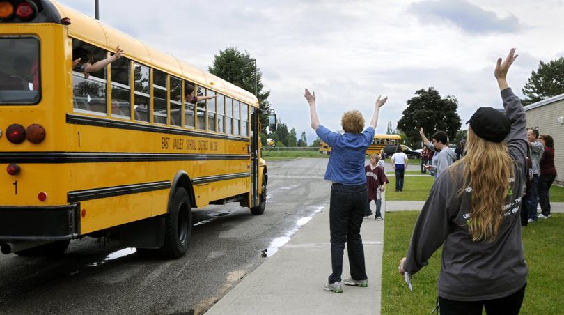 Mountain View Middle School social studies teacher, Lisa Nunlist (center) and athletic director, Angie Bordwell (right) wave goodbye as the last buses depart on the last day of school, June 17, 2011 in Newman Lake, Wash. The school is closing after 32 years.  (Dan Pelle)