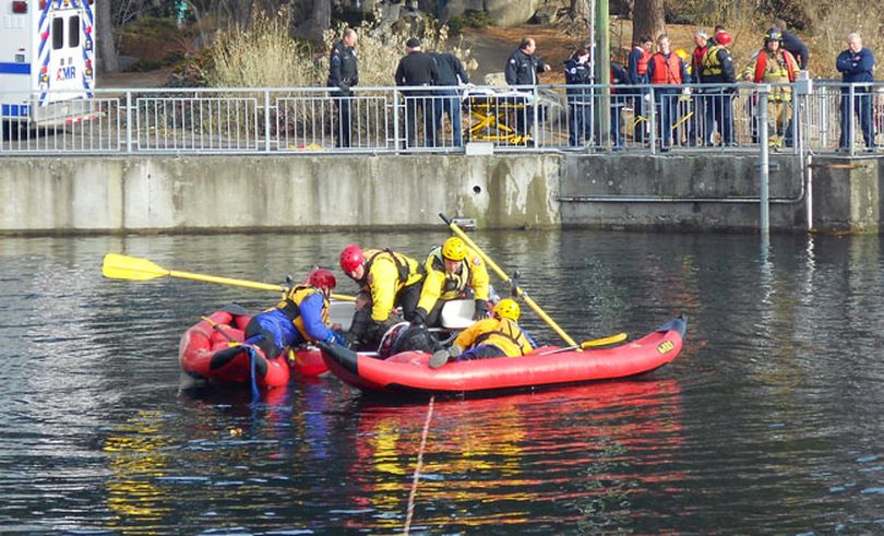 Crews rescue a man from the Spokane River in Riverfront Park today. (Meghann Cuniff / The Spokesman-Review)