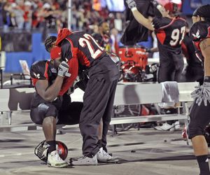 As the final seconds tick off the clock and the celebration begins, injured running back Taiwan Jones,right, goes to the bench to hug and comfort Renard WIlliams, left. The Eagles won the FCS National Championship with a come from behind 20-19 win over Delaware in Frisco Texas. (Christopher Anderson / The Spokesman-Review)