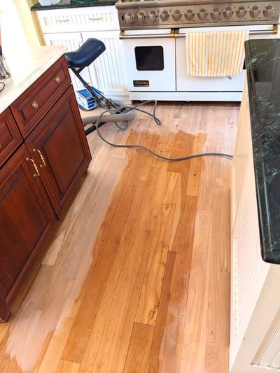 The old finish on this hardwood floor has been removed near the cabinets. The mind-numbing work of scraping up against the edges remains to be done. A tremendous amount of skill is required to produce a satin-smooth finish.  (Tribune News Service)