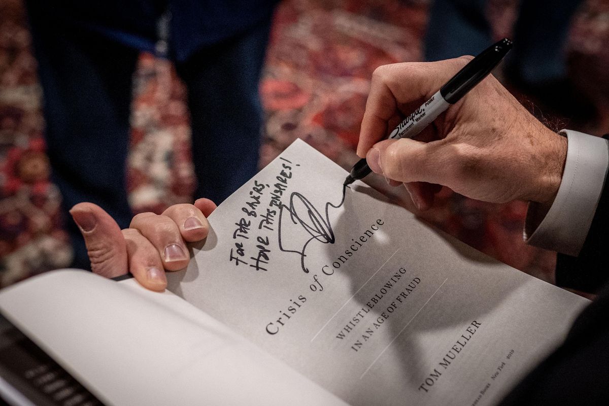 Tom Mueller, author of “Crisis of Conscience: Whistleblowing in an Age of Fraud,” signs his book on Mon., Oct. 28, 2019, during the Northwest Passages Book Club held at the Montvale Event Center. (Colin Mulvany / The Spokesman-Review)
