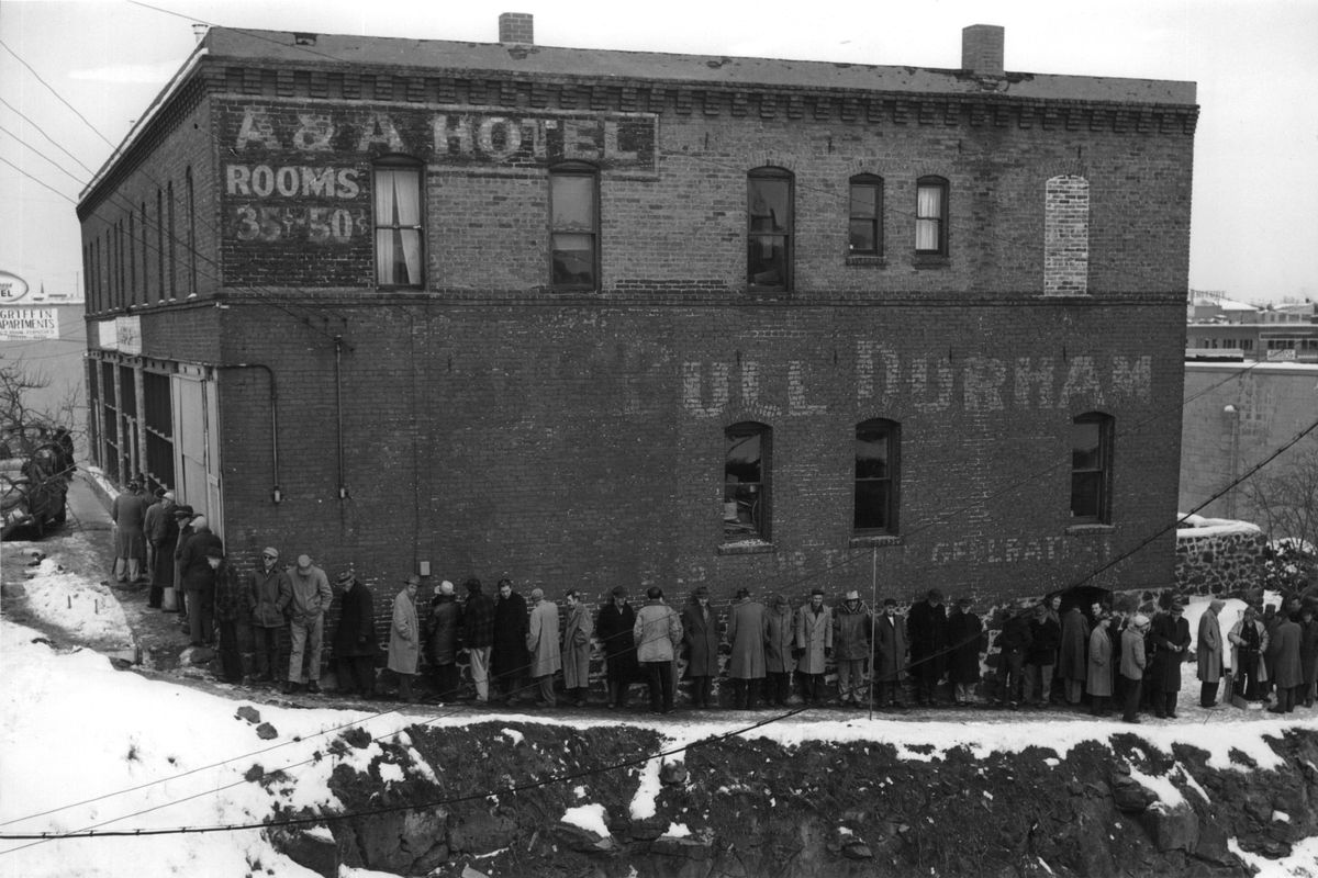 1960: A long line forms at noon outside the House of Charity, located at the time on Washington Street on Havermale Island in a former rooming house. Brothers of the Third Order of St. Francis operated the center for the homeless and unemployed. The building was once the A&A Hotel. (SPOKESMAN-REVIEW PHOTO ARCHIVE / SR)