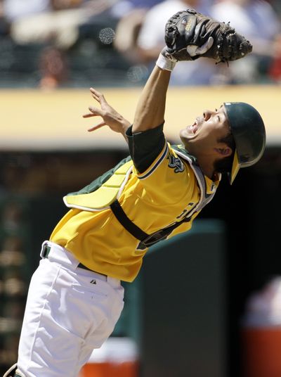 Athletics catcher Kurt Suzuki catches a popup by Dustin Ackley, one of seven hit by the Mariners. (Associated Press)