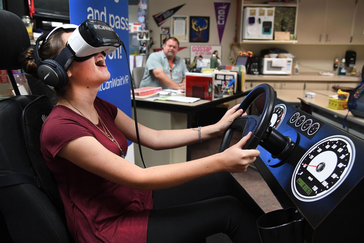 Christine Stephens, a junior at University High School, watches shattered glass fly during an automobile T-bone crash in her virtual reality goggles, Sept. 13, 2016, in Wally Watson