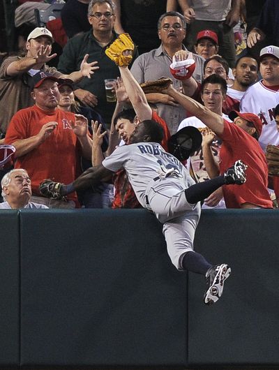 Mariners left fielder Trayvon Robinson had single and this standout catch in his major league debut. (Associated Press)