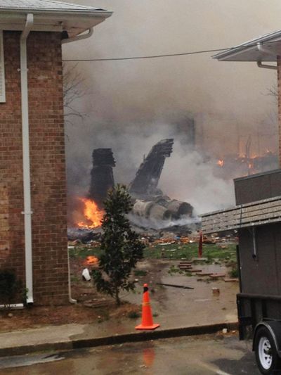 The fuselage of an F/A-18D lies smoldering after crashing into a residential building in Virginia on Friday. (Associated Press)