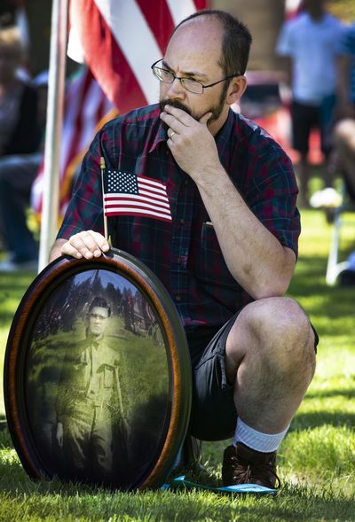 Brian Huseland holds a photograph of his great-uncle, Theodore Fournier, a veteran of World War I, during a Memorial Day ceremony at Fairmount Memorial Park in Spokane on Monday, May 28, 2018. “It is important for each generation to remember the past,” Huseland said. (Colin Mulvany / The Spokesman-Review)