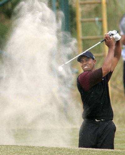 
Tiger Woods plays out of a bunker en route to bogey at No. 10, briefly giving the field hope before sealing the deal at No. 12.
 (Associated Press / The Spokesman-Review)