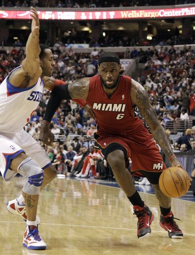 Miami's LeBron James drives around Philadelphia 76ers' Andre Iguodala. James scored 29 points in the Heat’s victory. (Associated Press)