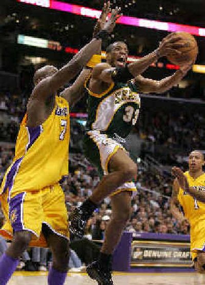 
Seattle's Antonio Daniels, right, eludes Los Angeles' Lamar Odom en route to the basket.
 (Associated Press / The Spokesman-Review)